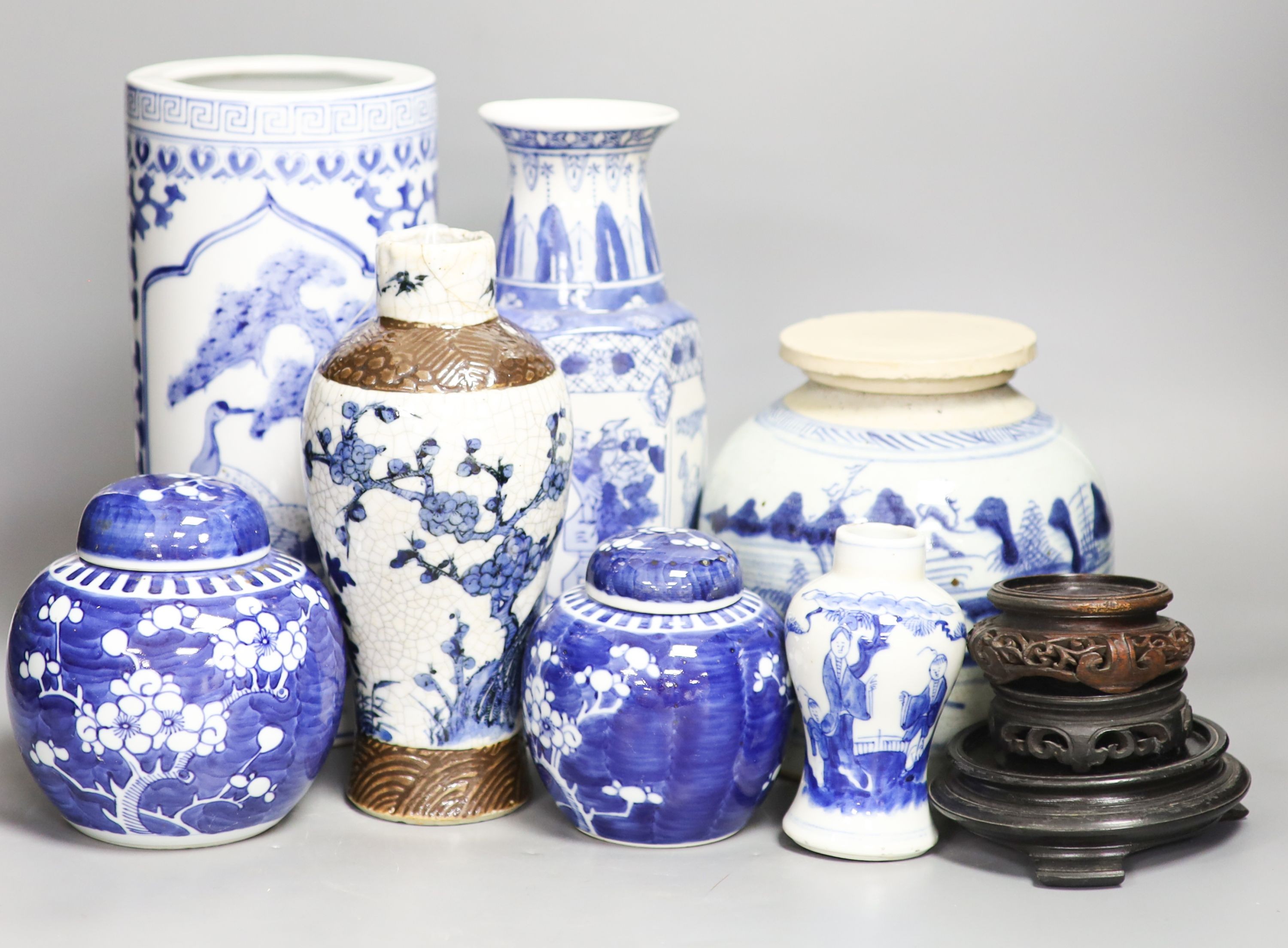 A group of seven Chinese blue and white porcelain vases and jars, 19th/20th century, and three wood stands 27cm